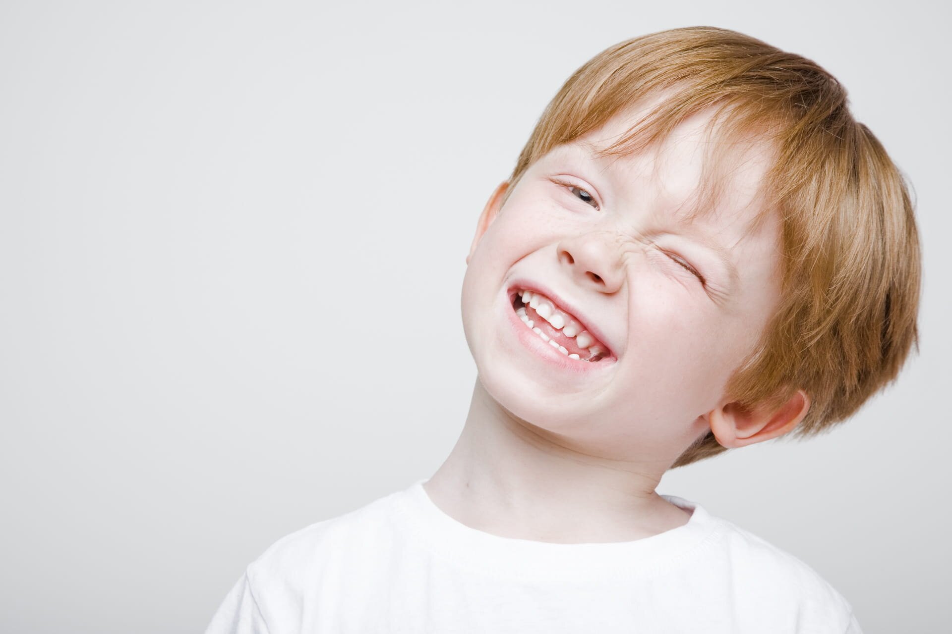 Laughing young boy with a gap in his baby teeth