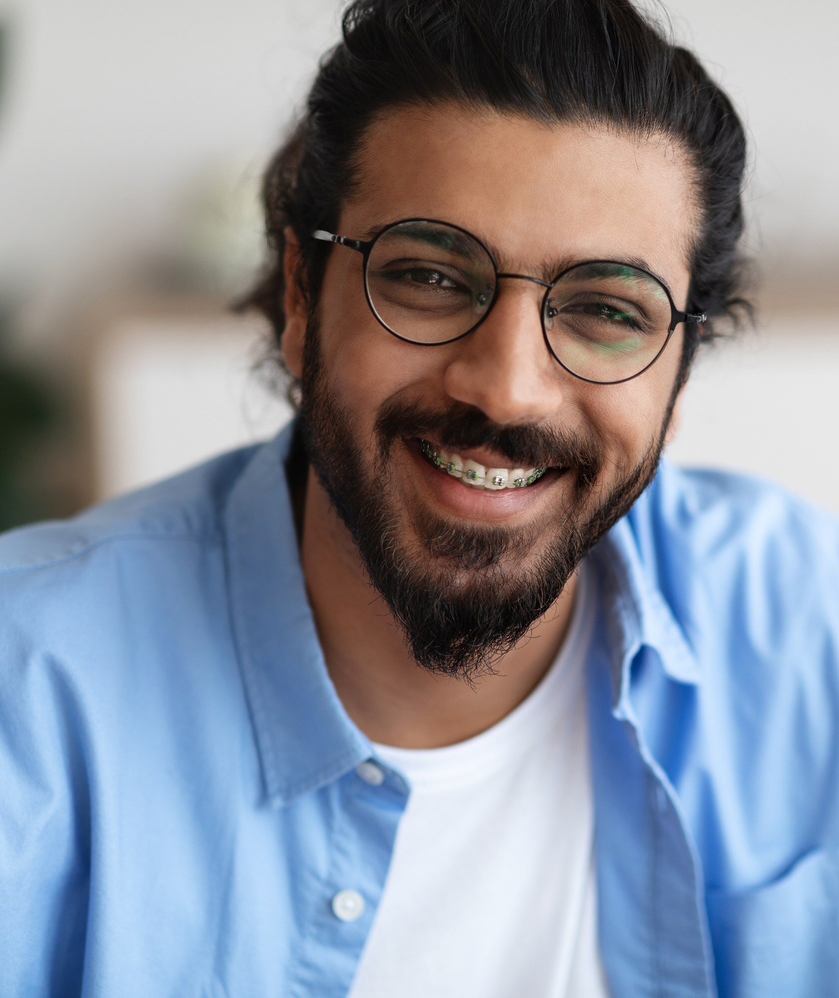 Smiling adult man wearing braces on his upper teeth